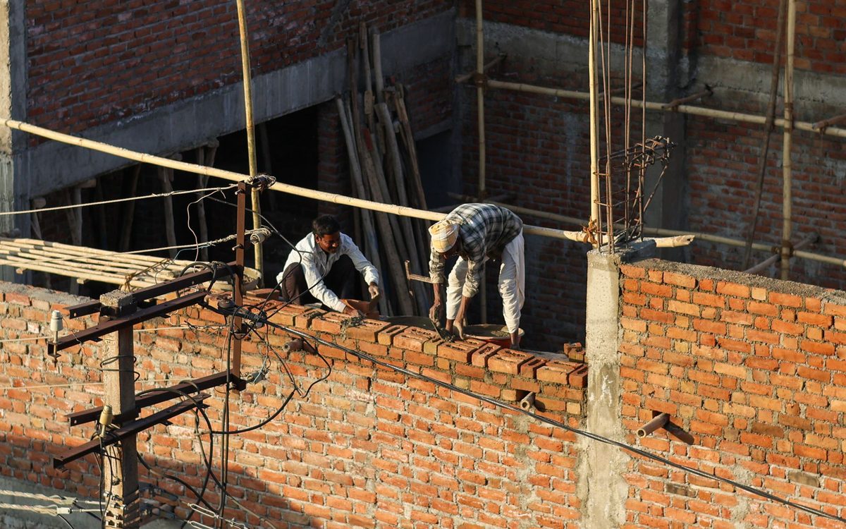 Pedreiros executando alvenaria e acabamento em obra residencial
