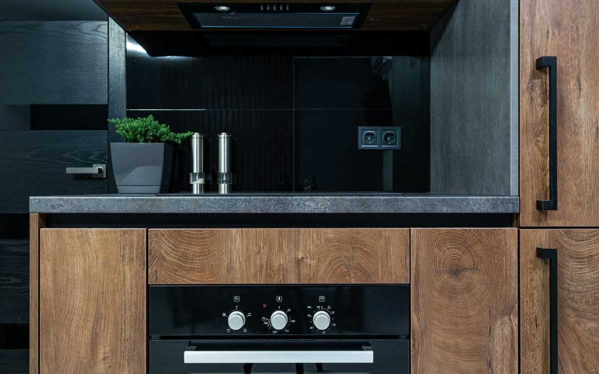 Cozinha gourmet planejada com acabamento em madeira e eletrodomésticos embutidos